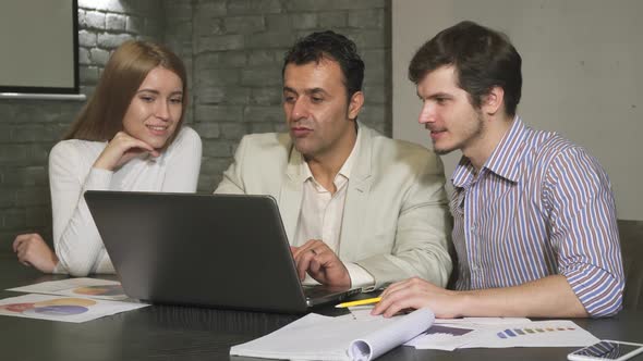 Hispanic Mature Businessman Helping His Employees During Business Meeting