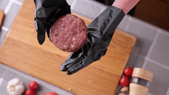 Woman Chef in Black Gloves Prepares Cutlets at Domestic Kitchen on a Wooden Cutting Board