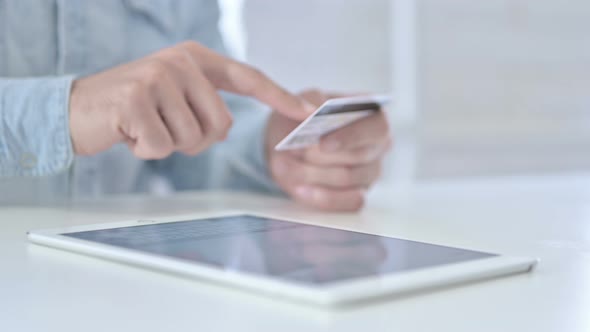 Close Up of Young Hands Using Credit Card on Tablet