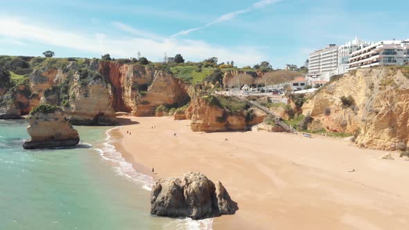 People enjoying majestic shoreline of heavenly Dona Ana beach, Lagos, Algarve, Portugal