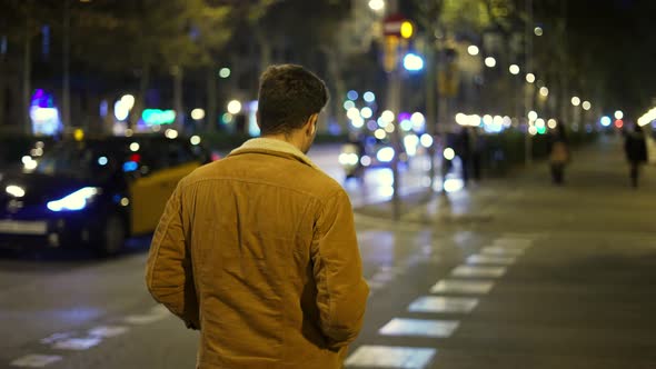 Man Starting to Cross Road at Night