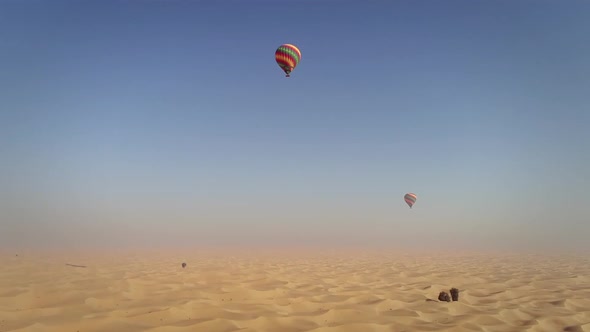 Aerial view of hot-air-balloon flying in the clouds on desert in Dubai, U.A.E.