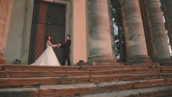 Wedding Couple Stands Together in Love at Ancient Castle's Door