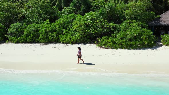 One woman loves life on perfect coastline beach lifestyle by blue green lagoon and white sandy backg