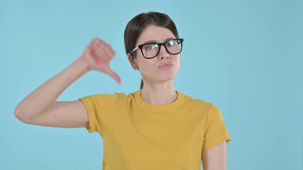 Serious Young Woman Doing Thumbs Down on Purple Background 