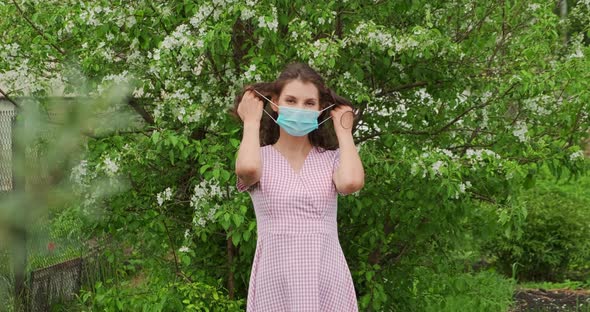 Girl Removes Medical Mask on Nature Near Tree and Takes Breath. Young Woman Takes Off on Mask. Slow