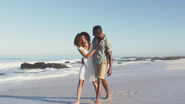 African American couple walking seaside