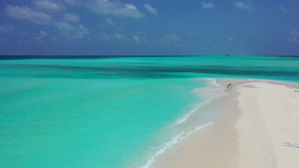 Beautiful fly over clean view of a white sandy paradise beach and blue water background 