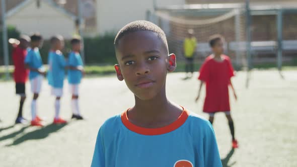 African American soccer kid in blue smiling and looking at camera