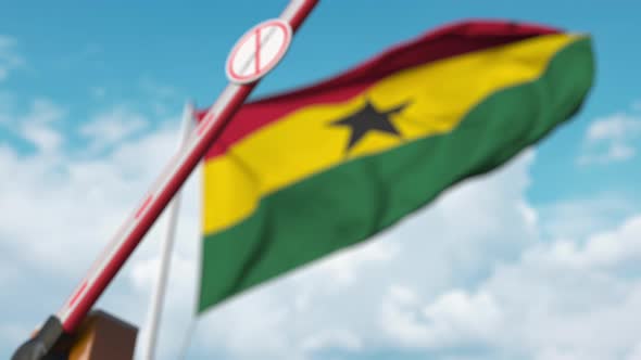 Closing Barrier with STOP CORONAVIRUS Sign at Flag of Ghana