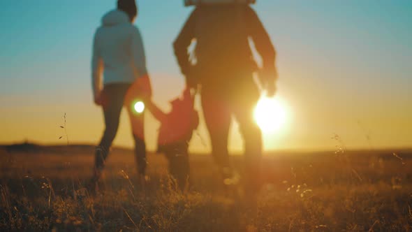 Silhouettes of Father, Mother and Little Son. Hiking Backpackers Trekking Mountains Summer. Young