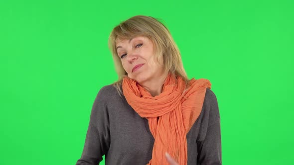 Portrait of Middle Aged Blonde Woman Is Shrugging and Sighing. Green Screen