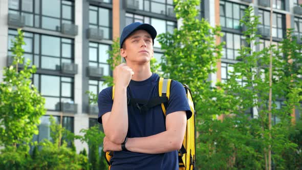 Thoughtful Man Courier with Backpack Looks Around Looking Delivery Address