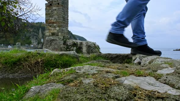 People Passing Over the Rocks by the Sea