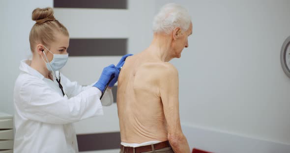 Female Doctor Examine Elderly Man with Stethoscope