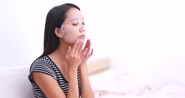 Woman apply paper mask on her face