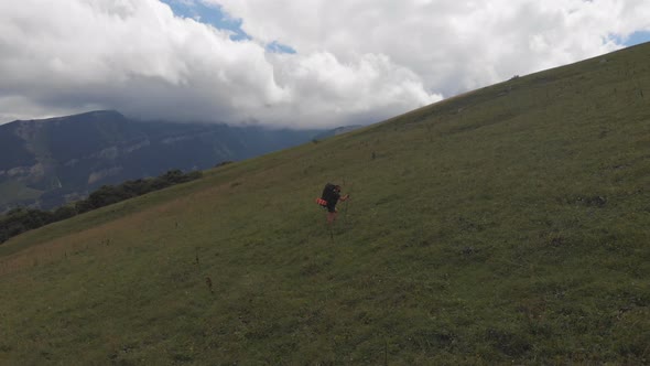 Aerial View of a Group of Tourists with Backpacks Climb the Mountain