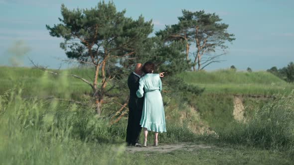 Wide Shot Woman in Elegant Dress Looking Away As Man in Suit Pointing in Slow Motion