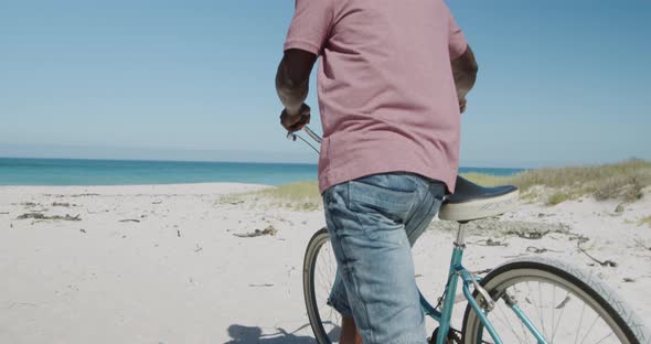 Senior man with a bike at the beach