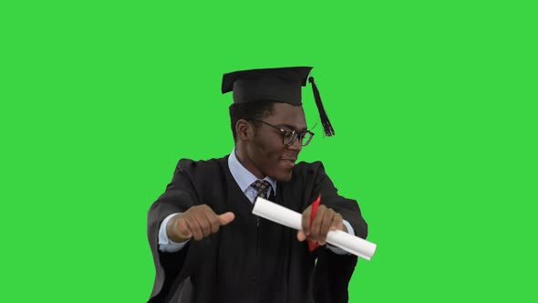 Excited African American Male Student Graduation Robe Dancing Happily His Diploma Green Screen