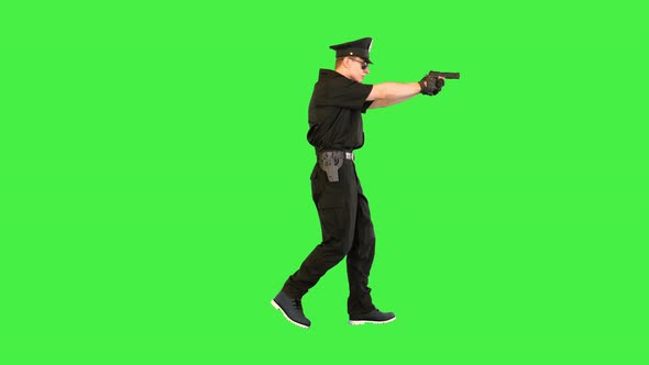 Young Policeman Walks Gets the Gun Out and Takes an Aim on a Green Screen Chroma Key