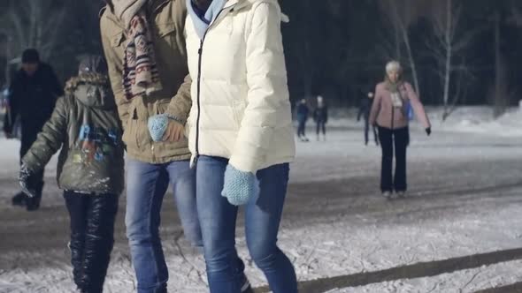 Couple Skating on Ice Rink in Evening
