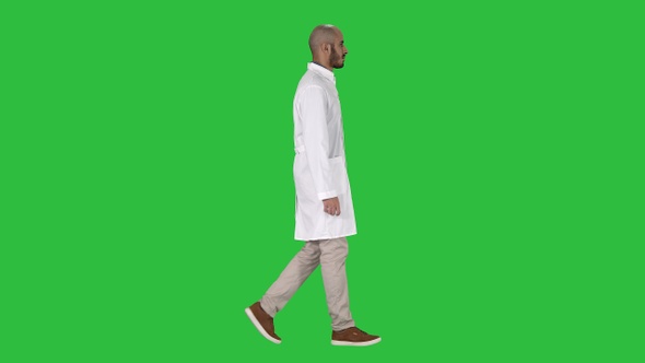 Arabian doctor in white robe walking on a Green Screen, Chroma Key.