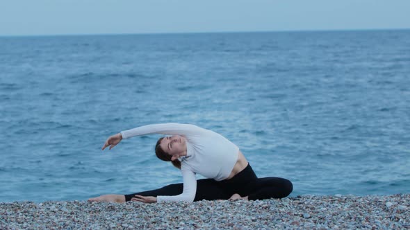 Sports Outdoors  a Woman Doing Yoga Exercises By the Blue Sea