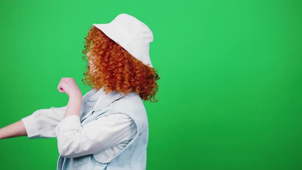 Cute Positive Redhead Curly Lady Wearing Eyeglasses and Panama Hat Dancing Moving Backward and