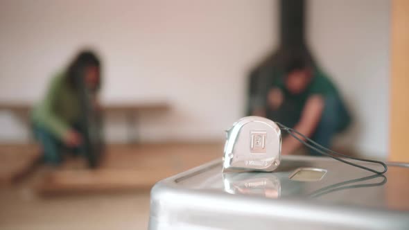 Close Up Of A White Tape Measure On The Table Inside The House.