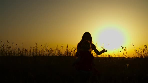 Loving Mother Embracing Toddler Girl at Sunset