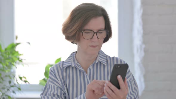 Senior Woman Celebrating on Smartphone