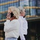 Businesswomen Talking on Mobile Phones While Walking By Office Building - VideoHive Item for Sale