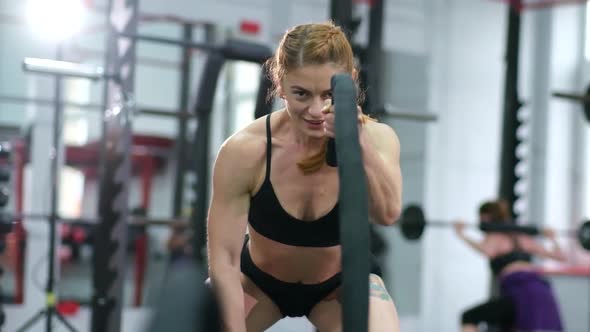 Athlete in Gym Exercising with Battle Ropes During Her Cross Fitness Workout