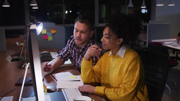 Young office executives discussing over computer in a modern office