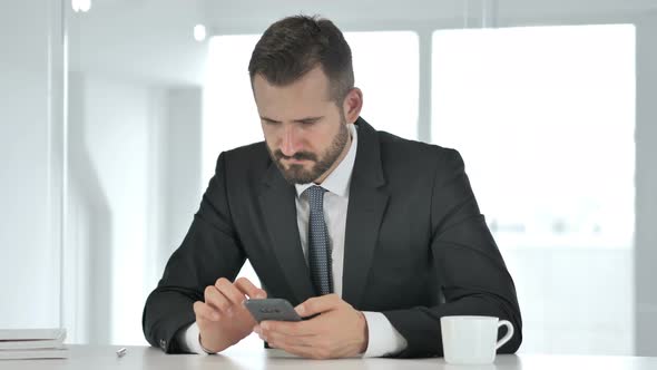 Businessman Using Phone for Reading Email