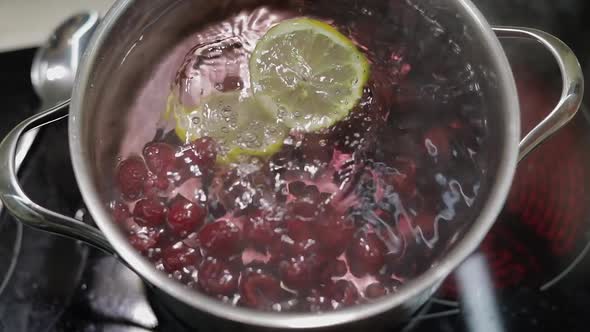 Add Slice of Lemon in Pan with Water and Berries. Red, Black Currant, Raspberry