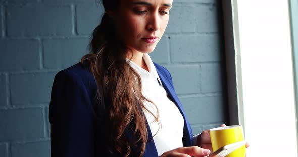 Businesswoman text messaging on mobile phone