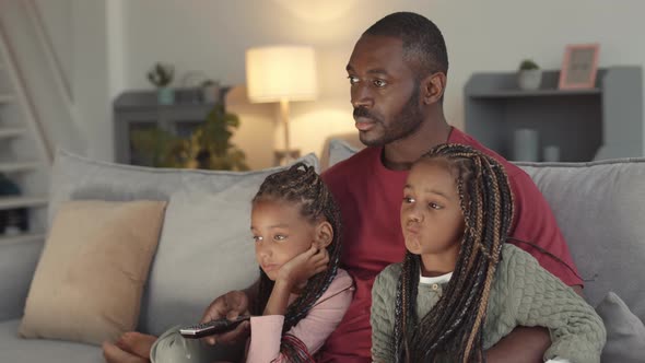 Father and Daughters Watching TV at Home