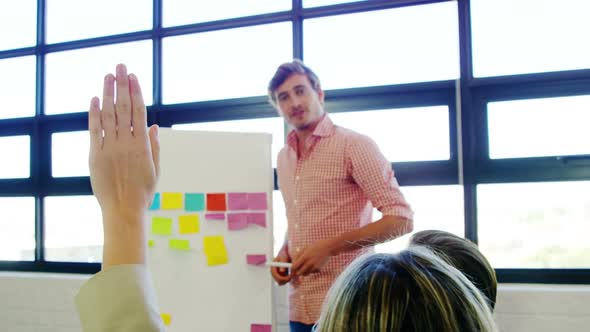 Male executive giving presentation to colleagues in office