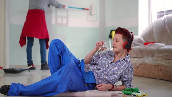 Wide Shot Relaxed Woman in Headphones Drinking Champagne Listening to Music with Unrecognizable