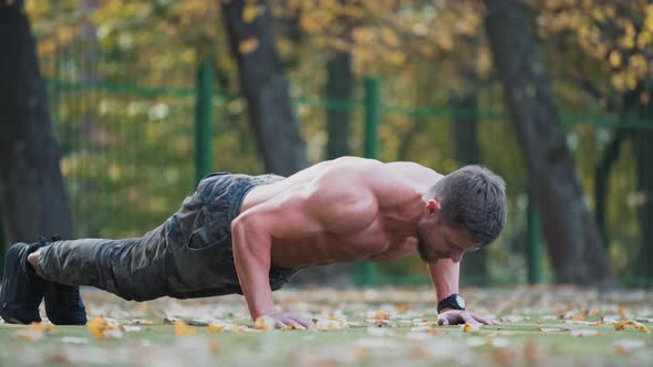 Young sportsman doing push ups. Handsome sport man doing push ups in the park