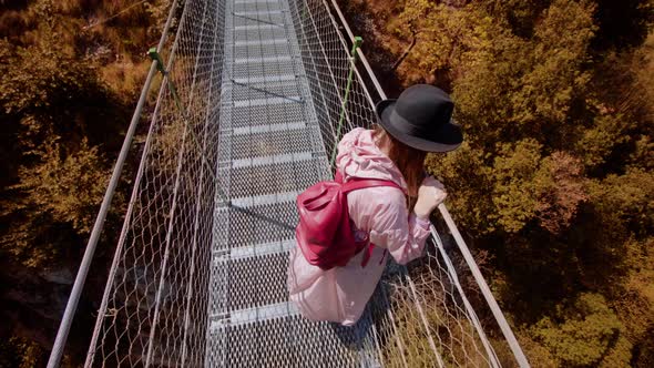 Woman Looks at Lake Garda Standing on Footbridge Over Park