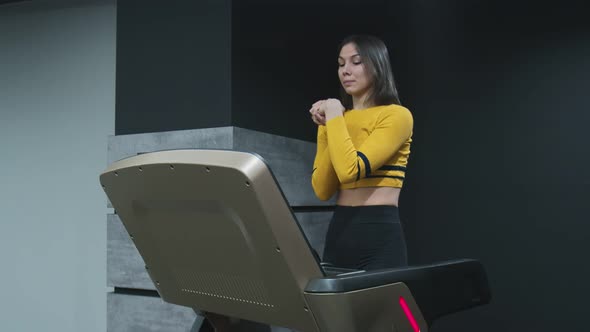 Fitness Woman Warm Up While Walks on Treadmill in Gym