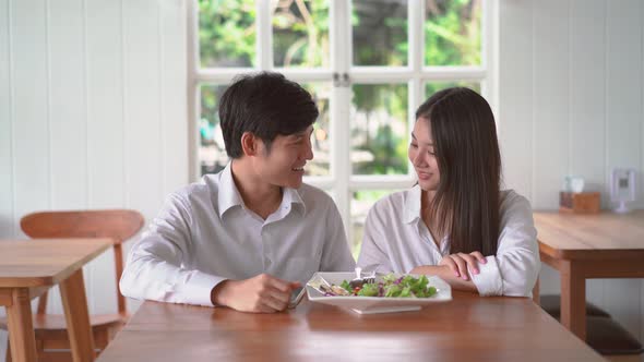 Happy couple posing taking selfie together use smartphone enjoying romantic date at restaurant.