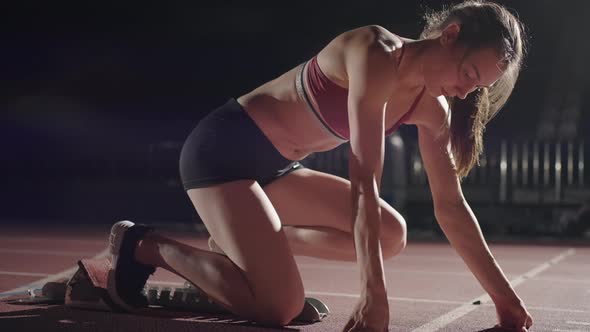 Woman Hand on Track As He Crouches in Starting Position at the Beginning of a Race