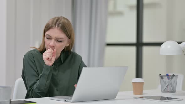 Young Woman Coughing While Using Laptop at Work 