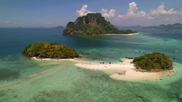 aerial establishing shot of Thale Waek Island full of mass tourism as thai longtail boats drop off t
