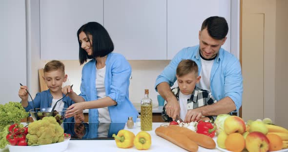 Family with Children which Having Fun Together while Cooking Useful Natural Vegetable Salad