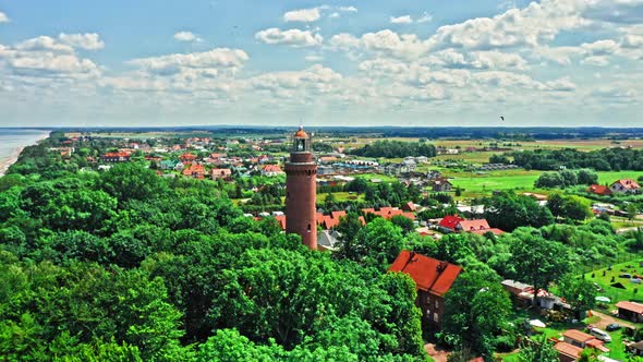 Lighthouse by forest and Baltic Sea in Poland, aerial view
